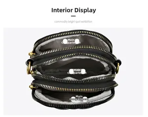 Vue intérieure du sac bandoulière en cuir noir avec trois poches zippées principales