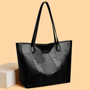 Black large-capacity tote bag with geometric patchwork and long shoulder straps