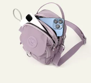Vue détaillée du mini sac bandoulière en nylon violet à compartiments zippés