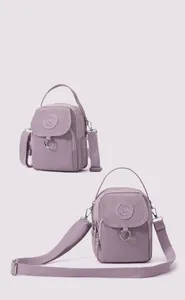 Détail d'un sac bandoulière léger en nylon lavande avec compartiments à fermeture éclair