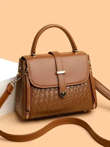 Vintage woven brown crossbody handbag with top handle and gold hardware in studio setting