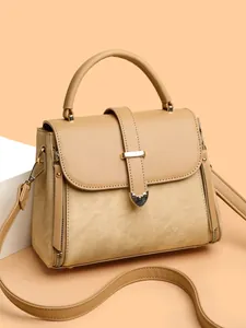 Elegant beige woven texture handbag with top handle and gold hardware on orange background