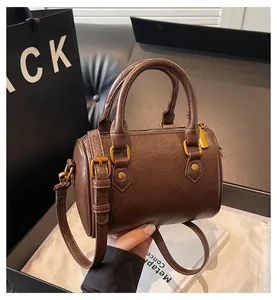 Detail view of deep brown vintage Boston bag with retro PU leather and bronze hardware