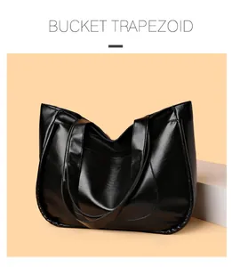 Detail of high-gloss black PU leather bucket trapezoid tote bag with long double straps