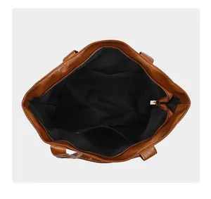 Top view of large tote bag interior showing brown litchi grain and functional pockets