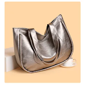 Detail of silver metallic tote bag featuring premium leather texture and stitched handle