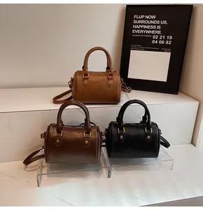 Detailed trio of vintage Boston bags in brown, dark coffee, and black faux leather