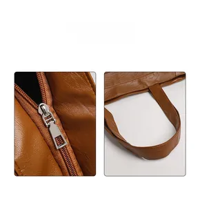 Detail of silver metal zipper and textured brown leather stitching on tote bag