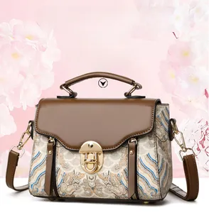 Detail of vintage crossbody bag with intricate wave patterns and golden metal lock