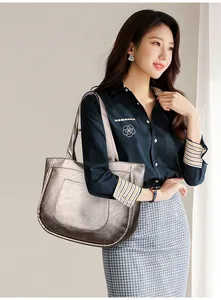 Silver tote bag with pleated texture shown on shoulder for daily commute look