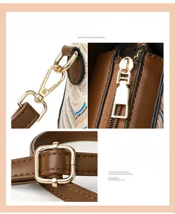 Close-up of light gold plated hardware including snap hooks and zippers on brown leather bag