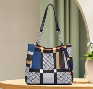 Detail of checkered tote bag with large capacity and elegant silver metal chain strap