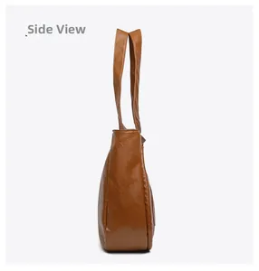 Side view of brown faux leather tote bag showing soft pebbled texture and shoulder strap