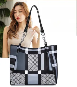 Detail of the chic geometric lattice tote bag featuring modern chain shoulder straps
