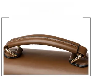 Detail of ergonomic dark brown leather handle with golden metal buckles and fine stitching