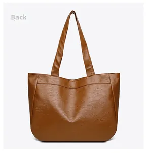Detailed back view of large brown leather tote bag with fine stitching and shoulder strap
