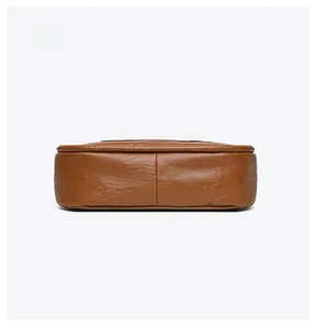 Detail view of the brown leather tote bag bottom with professional stitching and texture