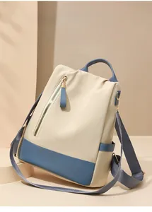 Détail d'un sac à dos antivol beige et bleu marine montrant la texture durable du nylon