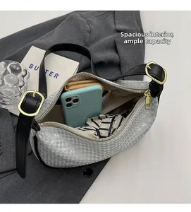 Detailed view of spacious interior of grey patterned shoulder bag with gold zipper