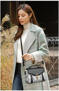 Detail of elegant crossbody bag featuring Chinese style landscape print and gold metal lock