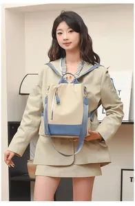 Détail d'un sac à dos en nylon beige et bleu avec plusieurs poches et fermetures à glissière