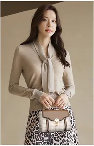 Detail of elegant beige crossbody bag with brown flap and golden clasp on a model