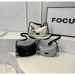 Detailed view of stylish dumpling bags in beige, black, and grey with cute bear charms