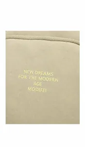 Close-up of the beige nylon fabric texture with printed brand lettering on the side