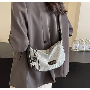Silver-grey hobo bag with adjustable wide strap and cute bear charm shown on model