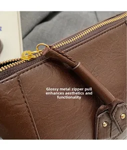 Nahaufnahme des goldenen Reißverschlusses und dunkelbraunem Leder an der Eimertasche