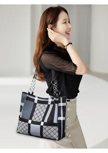 Detail of checkered nylon tote bag featuring metal chain strap and geometric patterns