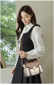 Detail of vintage crossbody bag showing floral pattern and golden metal turn-lock closure
