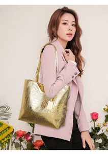 Lifestyle shot of large gold crocodile pattern tote bag styled with a pink suit for work