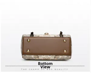 Detailed bottom view of the handbag featuring protective gold studs and textured jacquard