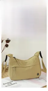 Detail shot of khaki nylon shoulder bag with zipper pulls and M FASHION logo
