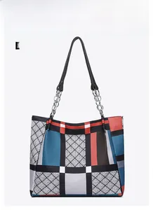 Close-up of geometric pattern tote bag with metal chain and leather shoulder strap