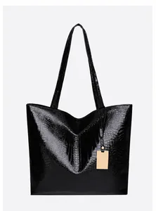 Detailed front view of black crocodile pattern tote bag with glossy finish and gold tag