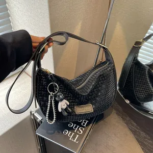 Black half-moon hobo bag with textured finish, silver hardware and cute bear pendant