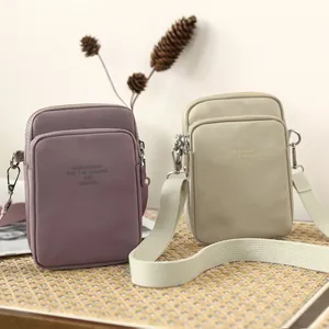 Minimalist nylon crossbody phone bags in pink and beige with adjustable shoulder straps