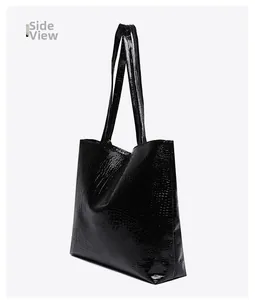 Detail of black crocodile texture and wide side view on this large tote bag