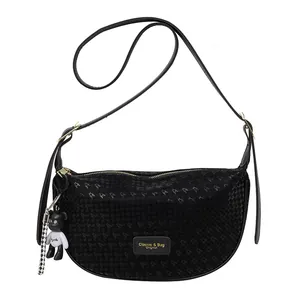 Black crescent bag with star texture, gold zipper, and bear charm on white background
