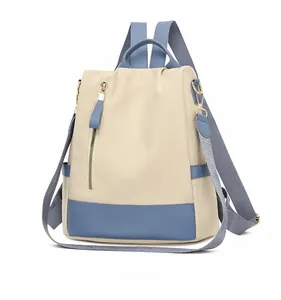 Vue latérale du sac à dos antivol beige avec bordures bleues et détails dorés