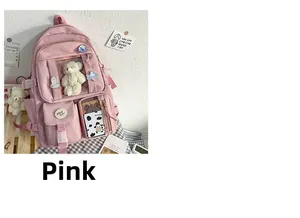 Detalle de mochila rosa de oxford con oso de peluche y pines de dibujos animados
