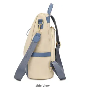 Vue latérale du sac à dos antivol crème avec sangles bleues et détails dorés