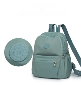 Detail of Morandi green oxford backpack showing brand logo and waterproof texture