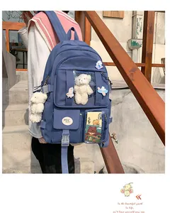Detail eines dunkelblauen Schülerrucksacks mit Plüschbär und mehreren Fächern