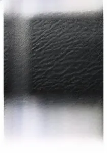 Detail of black lychee grain leather handbag with iconic golden H-shaped metal buckle