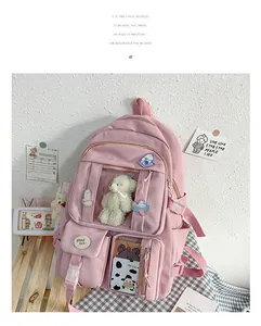 Nahaufnahme des rosa Schülerrucksacks mit süßen Anhängern, Aufnähern und Mehrfachtaschen-Detail