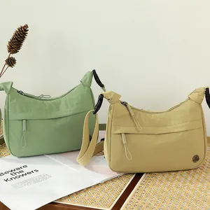 Minimalist nylon crescent crossbody bags in green and khaki with utility buckle strap
