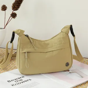 Beige nylon hobo shoulder bag with adjustable wide strap and round metal logo detail